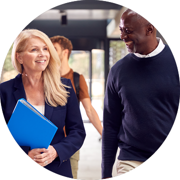 Male And Female Tutors In Busy University Or College Building With Students